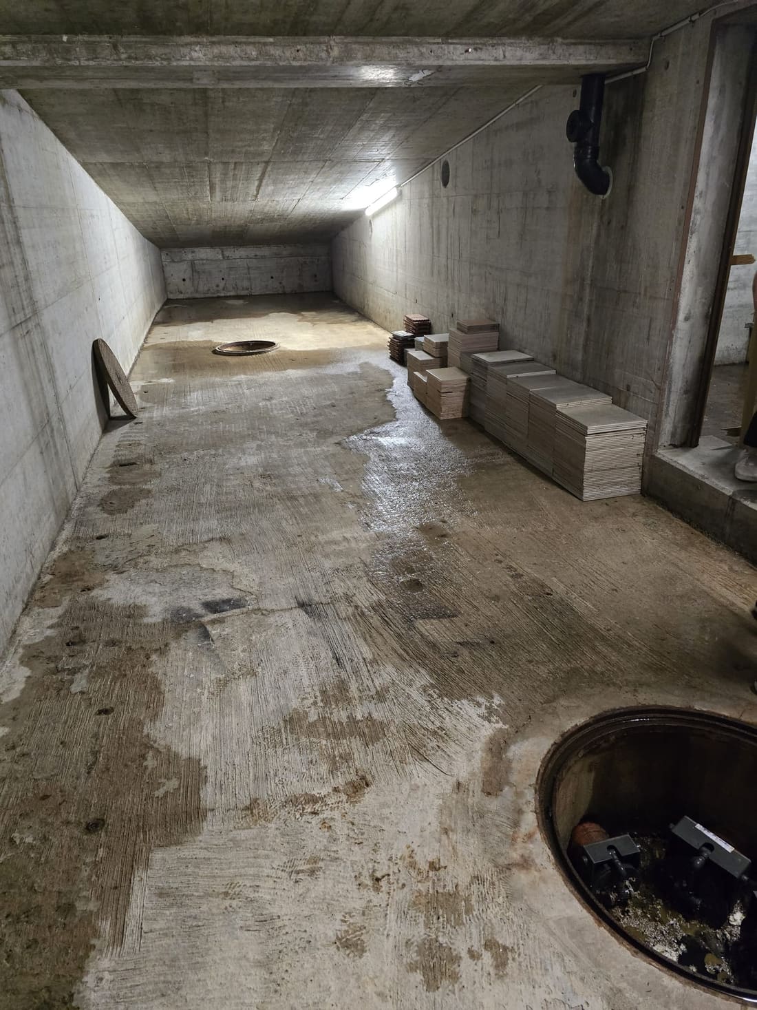 Sous-sol inondé, regard ouvert sur la pompe de relevage